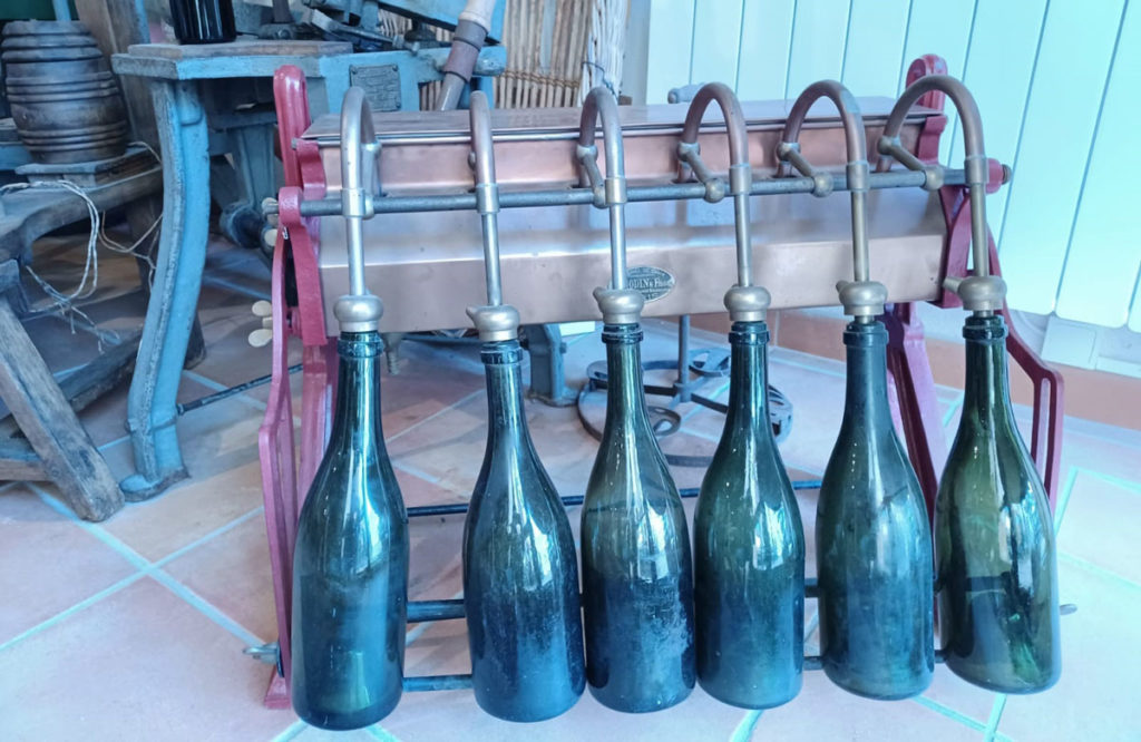 Garrafas de champanhe em máquina antiga de encher (foto de Míriam Aguiar)